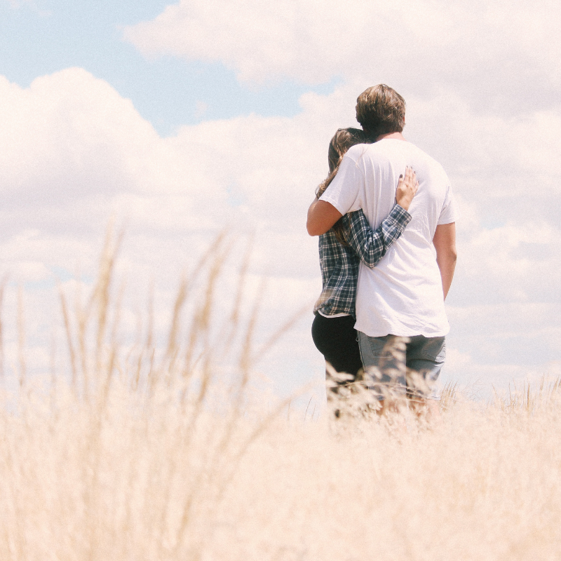 couple hugging in field